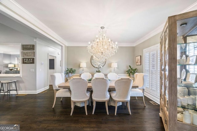 dining room with dark wood-type flooring, a chandelier, and ornamental molding