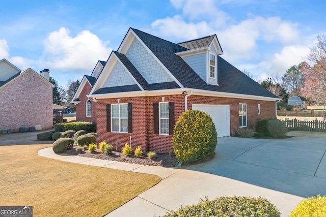 view of home's exterior with driveway, a garage, a lawn, fence, and brick siding