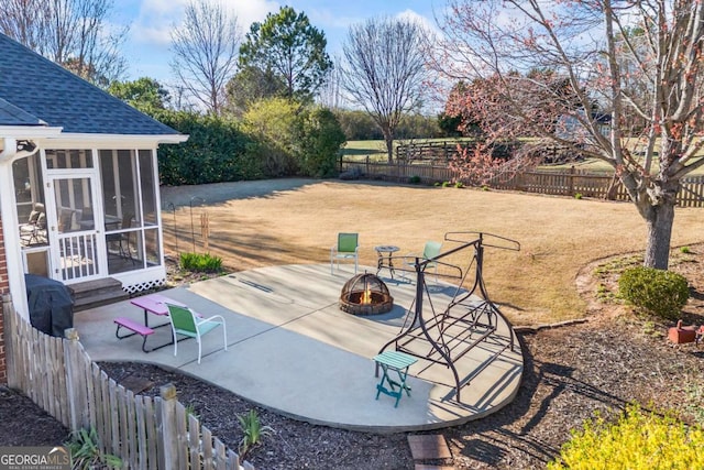 view of patio / terrace with a sunroom, an outdoor fire pit, and a fenced backyard