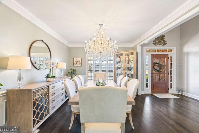 dining area with baseboards, crown molding, a chandelier, and wood finished floors