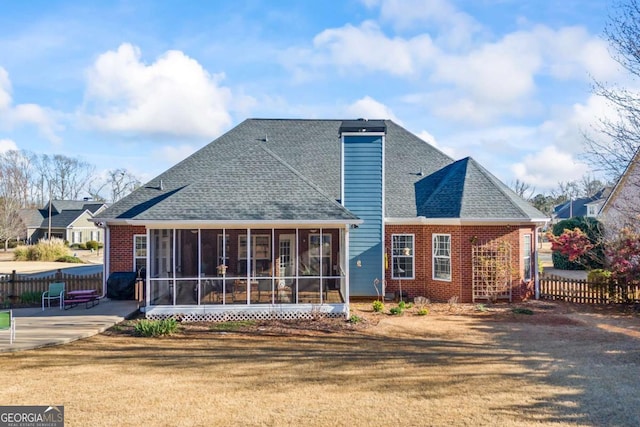 back of house featuring fence, a sunroom, a yard, a chimney, and a patio area