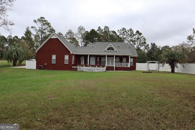 view of front facade featuring a porch, fence, and a front lawn