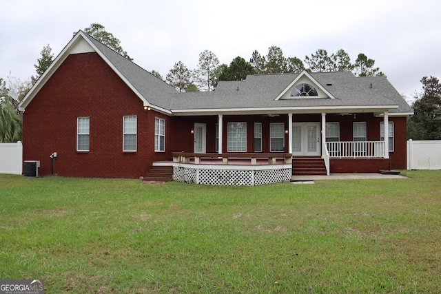 view of front of house featuring brick siding, fence, a front lawn, and central air condition unit