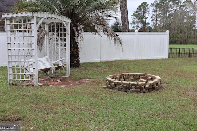 view of yard featuring an outdoor fire pit and fence