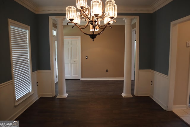 unfurnished dining area featuring decorative columns, crown molding, wood finished floors, and wainscoting