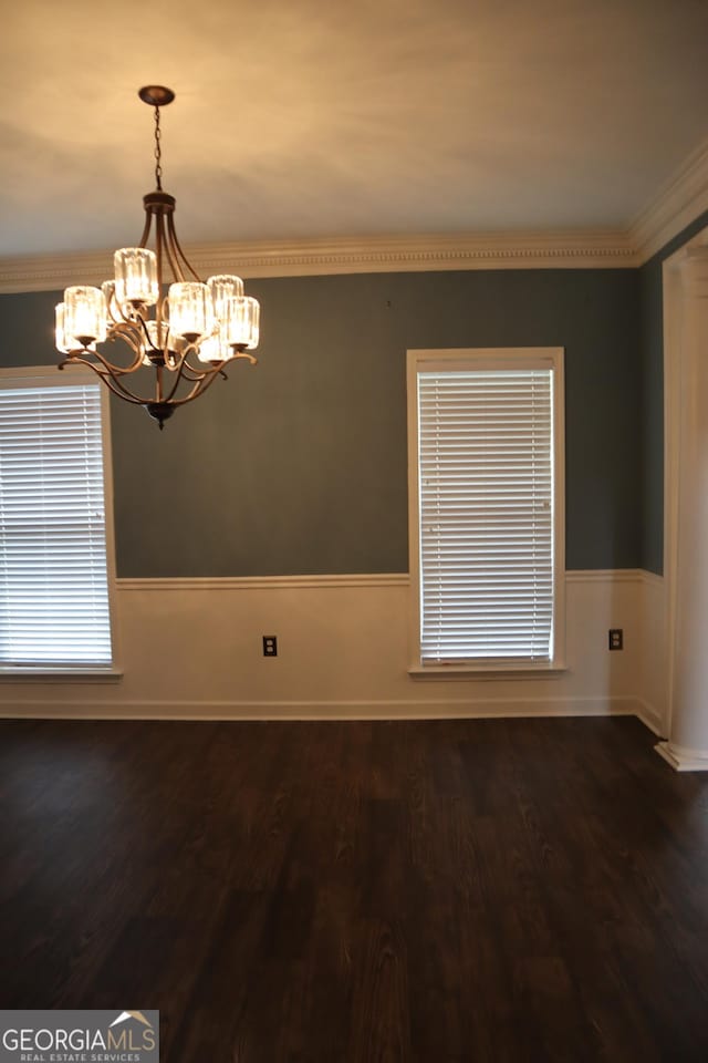 unfurnished room with dark wood-style flooring, a wainscoted wall, and a notable chandelier