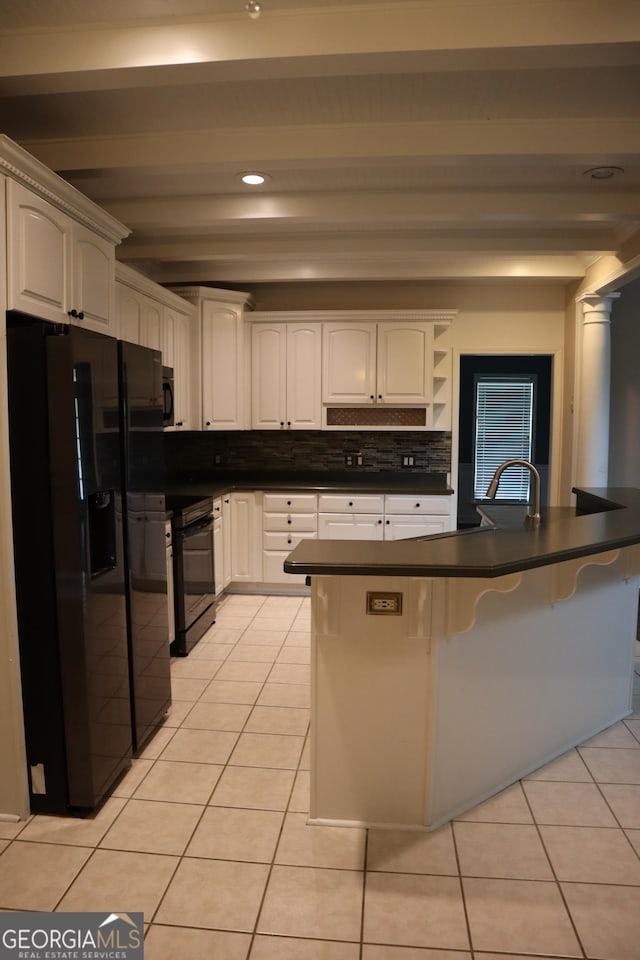 kitchen featuring light tile patterned floors, a breakfast bar area, black appliances, beamed ceiling, and dark countertops