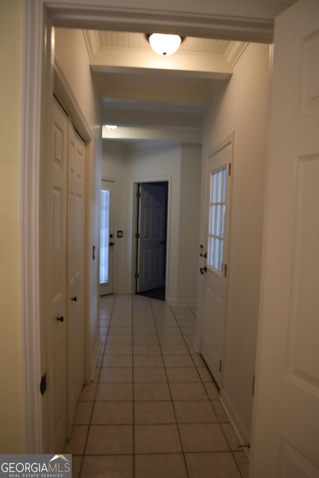 hallway featuring wood ceiling, beam ceiling, baseboards, and light tile patterned floors