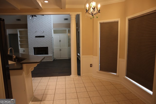 interior space featuring light tile patterned floors, dark countertops, open floor plan, beamed ceiling, and ornate columns