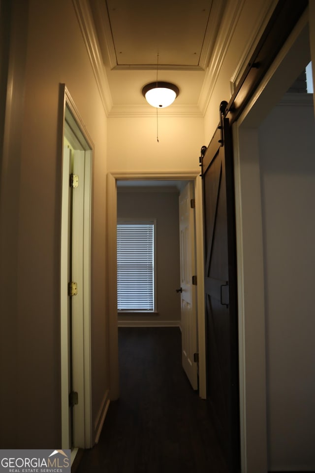 hall with attic access, ornamental molding, and a barn door