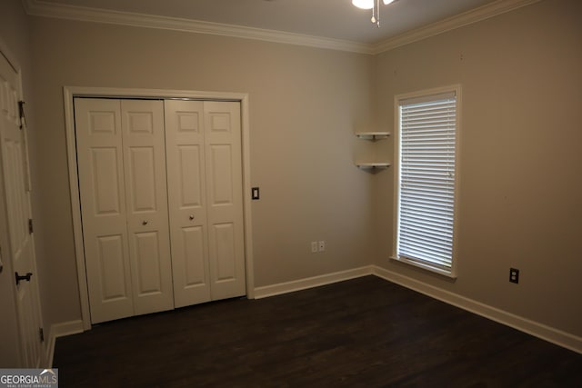 unfurnished bedroom featuring ornamental molding, dark wood-type flooring, a closet, and baseboards