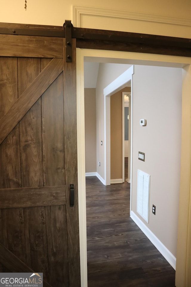 hall with visible vents, baseboards, and dark wood finished floors