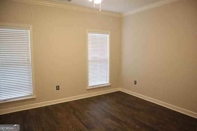 empty room with ornamental molding, baseboards, ceiling fan, and dark wood finished floors