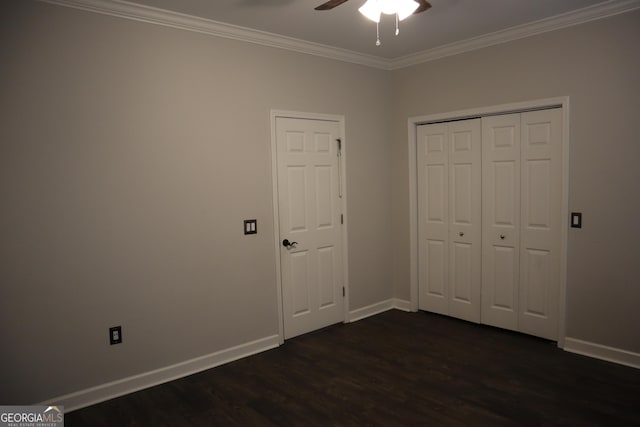 unfurnished bedroom with crown molding, dark wood finished floors, a closet, a ceiling fan, and baseboards