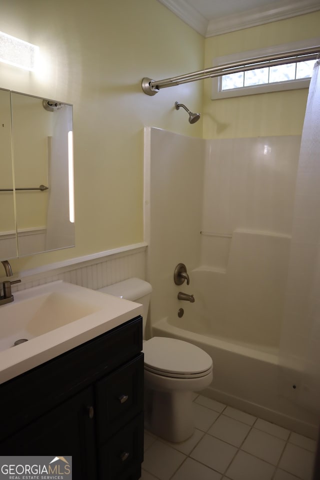 bathroom with washtub / shower combination, toilet, vanity, a wainscoted wall, and tile patterned flooring