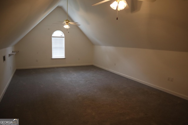 bonus room featuring dark colored carpet, lofted ceiling, visible vents, ceiling fan, and baseboards