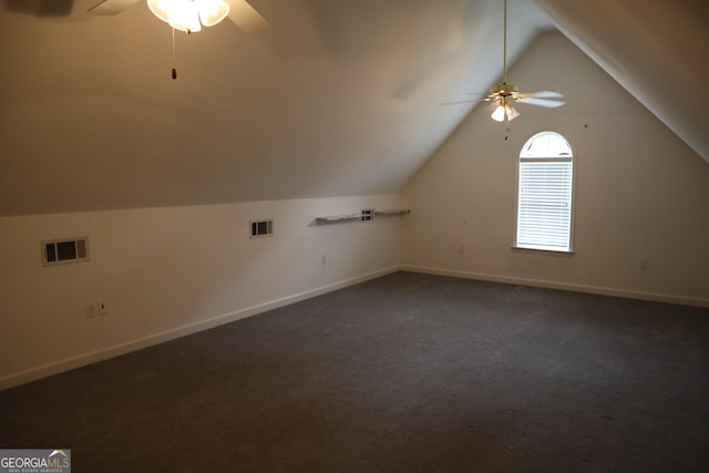 additional living space featuring visible vents, baseboards, vaulted ceiling, a ceiling fan, and dark carpet