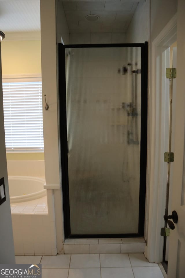 full bathroom with a bath, a shower stall, and tile patterned flooring