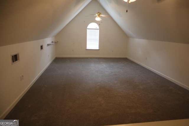 additional living space with baseboards, vaulted ceiling, a ceiling fan, visible vents, and dark carpet