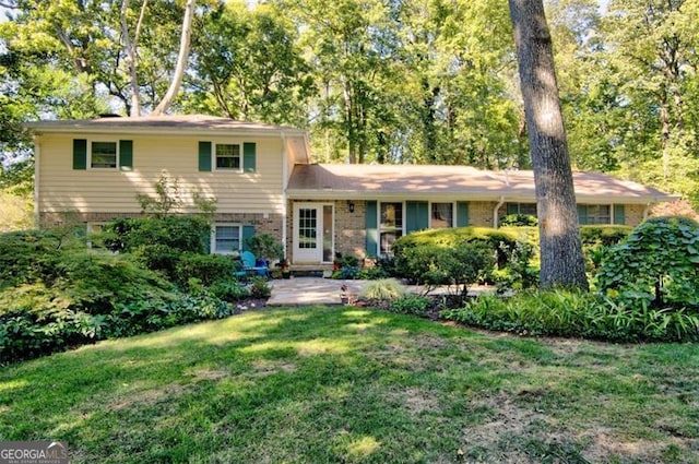 tri-level home featuring brick siding and a front lawn