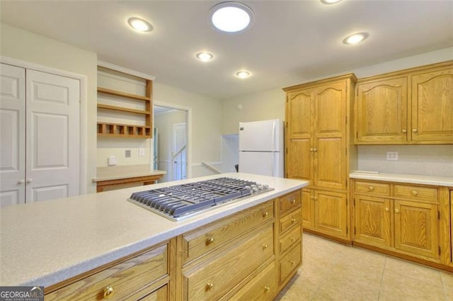 kitchen with recessed lighting, light countertops, freestanding refrigerator, open shelves, and stainless steel gas stovetop