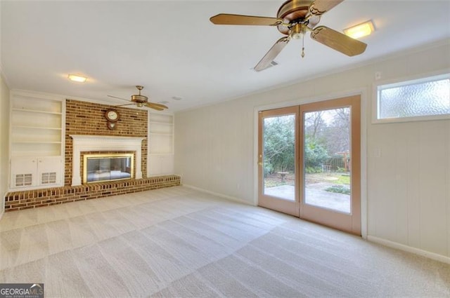 unfurnished living room with built in shelves, a fireplace, carpet flooring, and baseboards