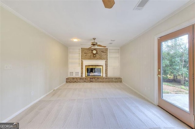 unfurnished living room with ceiling fan, built in shelves, a fireplace, and plenty of natural light