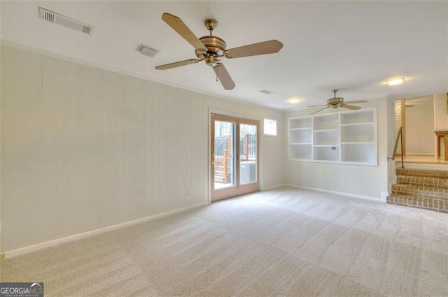 unfurnished living room featuring crown molding, visible vents, light carpet, baseboards, and stairs