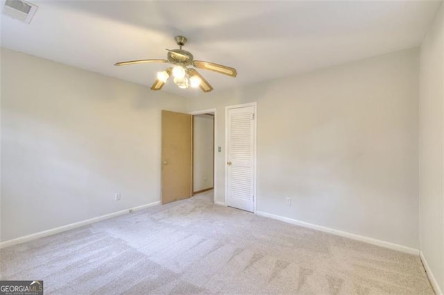 unfurnished room with a ceiling fan, carpet, visible vents, and baseboards