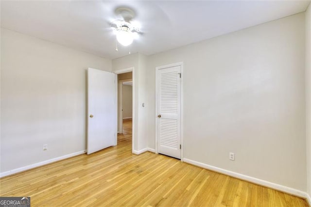 unfurnished bedroom featuring a closet, baseboards, and wood finished floors