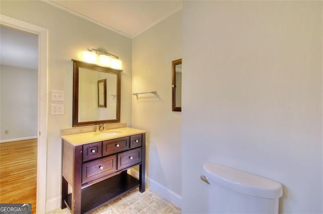 bathroom featuring toilet, baseboards, and vanity