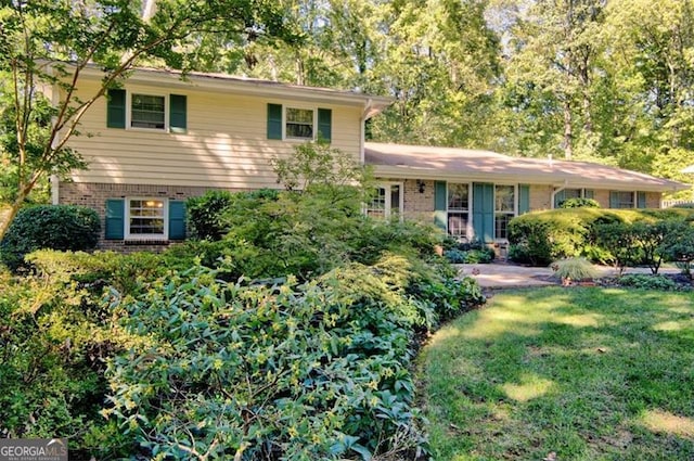 split level home with a front yard and brick siding