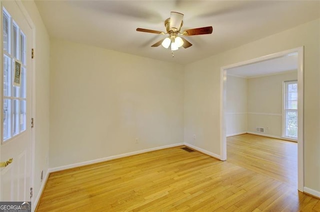 empty room featuring visible vents, a ceiling fan, light wood-style flooring, and baseboards