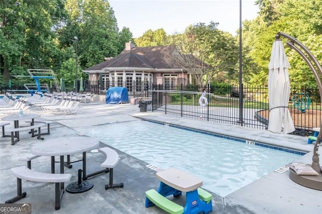 community pool featuring a patio area and fence