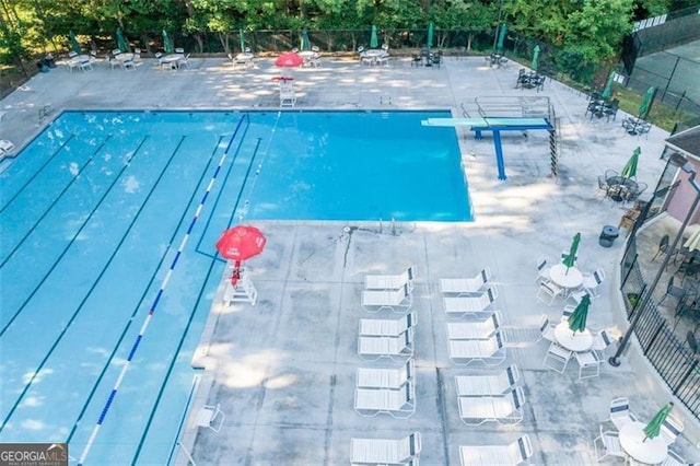 pool featuring a diving board and fence