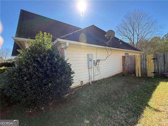 view of side of property with a yard and fence