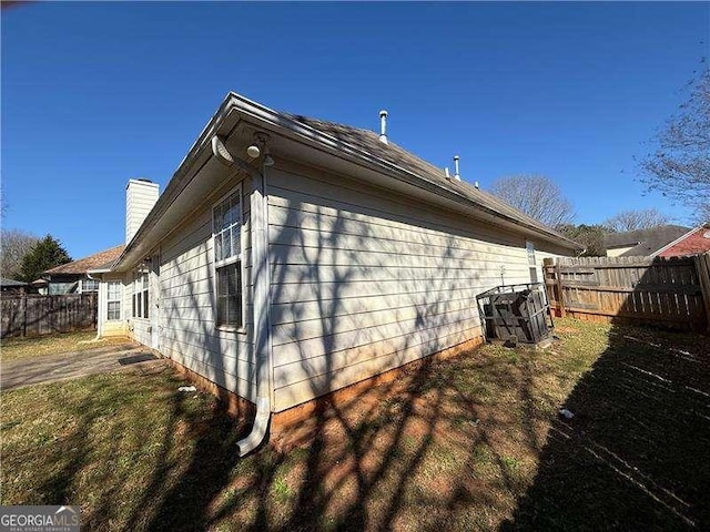 view of home's exterior featuring a chimney and a fenced backyard