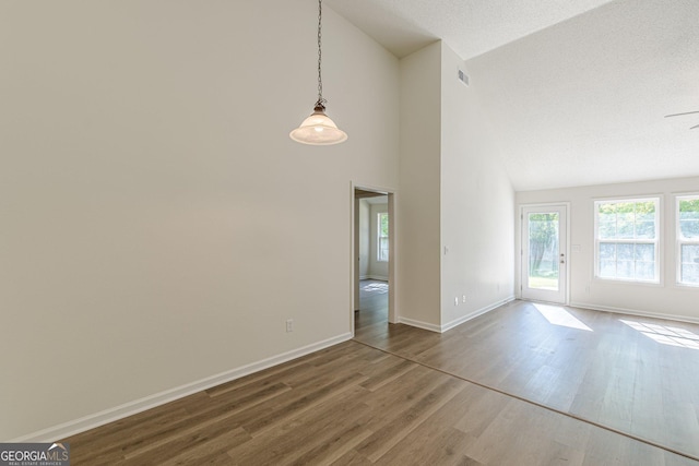 interior space featuring high vaulted ceiling, baseboards, and wood finished floors