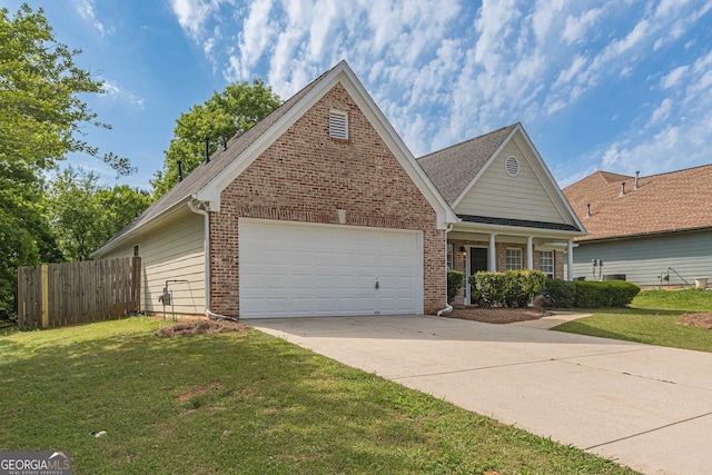 view of front facade with fence, a front lawn, an attached garage, driveway, and brick siding