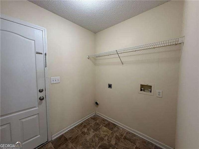 laundry area featuring hookup for a washing machine, hookup for an electric dryer, a textured ceiling, laundry area, and baseboards