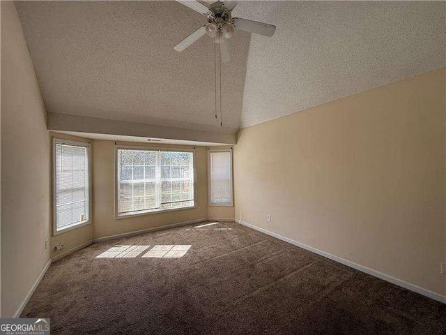 unfurnished room featuring lofted ceiling, a textured ceiling, carpet flooring, a ceiling fan, and baseboards