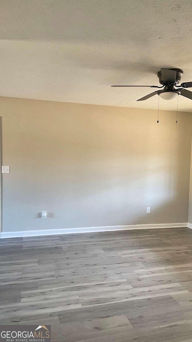 unfurnished room featuring a ceiling fan, a textured ceiling, baseboards, and wood finished floors