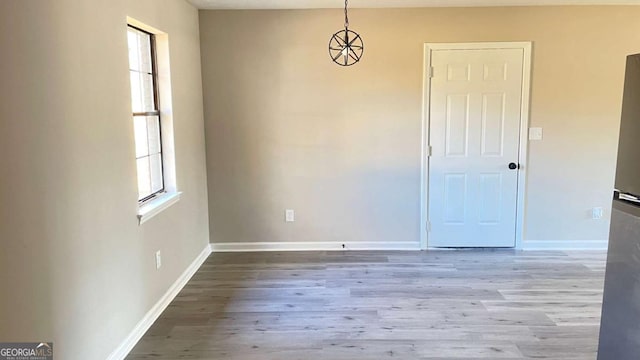 unfurnished room with baseboards and wood finished floors