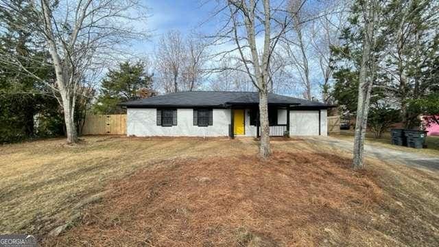 single story home featuring a garage, driveway, and fence