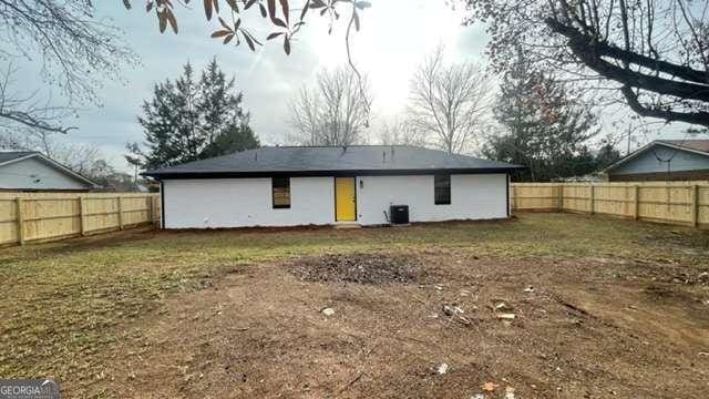 rear view of house featuring a fenced backyard