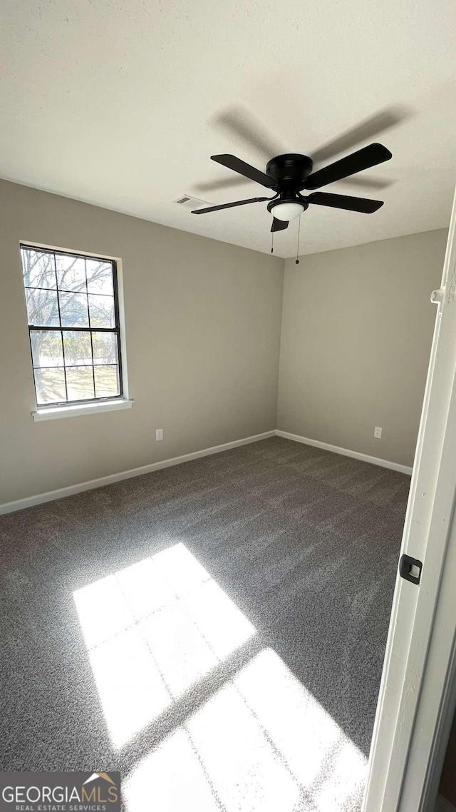 carpeted spare room featuring visible vents and baseboards