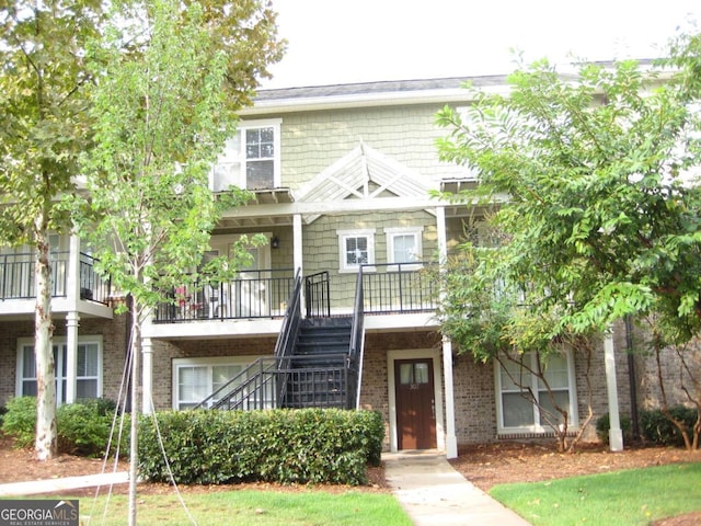 townhome / multi-family property with stairs and brick siding