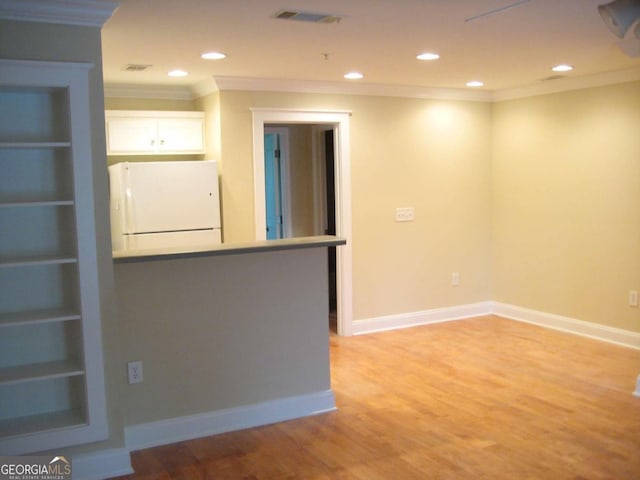 interior space featuring baseboards, ornamental molding, visible vents, and light wood-style floors