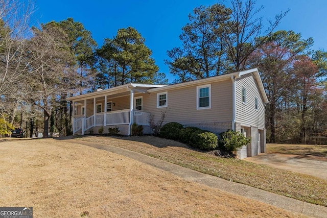 ranch-style home with brick siding, a porch, an attached garage, driveway, and a front lawn