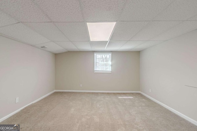 below grade area with carpet, a drop ceiling, visible vents, and baseboards